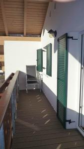 une terrasse couverte avec des fenêtres à volets verts et un banc dans l'établissement Haus Vallaster, à Sankt Gallenkirch