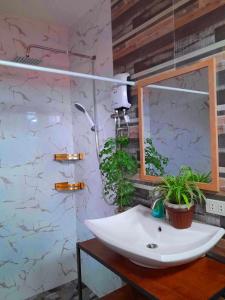 uma casa de banho com um lavatório branco e um espelho. em Liturs Travel Services / Homestay / Rent a Car em Bacolod