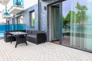 a patio with a table and chairs next to a pool at Berill Suites in Sárvár