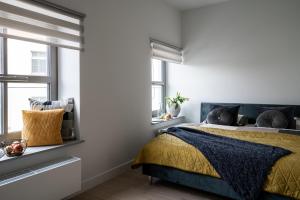 a bedroom with a bed and two windows at Apartments City Center Wroclaw - MAMY WOLNE POKOJE ! in Wrocław