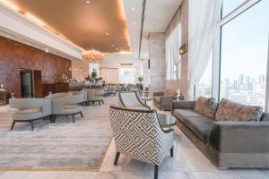 a lobby with a couch and chairs and a bar at Grand Majestic Hotel Kuwait in Kuwait