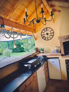 a kitchen with a stove and a clock on the wall at Le Moulin du Château de Horgues in Horgues
