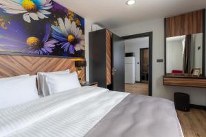 a bedroom with a white bed and a painting of flowers at Yusufhan Suites in Trabzon