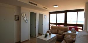 een woonkamer met een bank en een tafel bij Apartamento jardin del mar 7.5 in La Manga del Mar Menor
