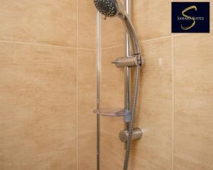 a shower with a shower head on a wall at Cosy Business Haven - 3 Bed Newcastle City - FREE PARKING in Newcastle upon Tyne