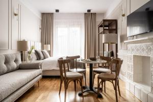a living room with a bed and a table and chairs at Avanti Palazzo in Krakow