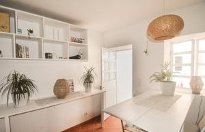 une salle à manger avec une table blanche et des plantes en pot dans l'établissement SHARED APARTMENT WITH BRIGHT PRIVATE PATIO IN LISBOA, à Lisbonne