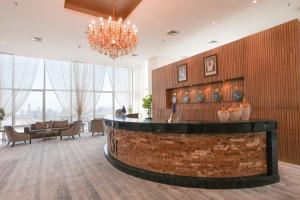 a lobby with a bar with a chandelier at Grand Majestic Hotel Kuwait in Kuwait