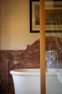 bañera blanca en el baño con una foto en Grand Hotel Son Net, en Puigpunyent
