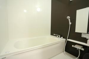 uma banheira branca na casa de banho com um espelho em KINHOMARU - Vacation STAY 81323v em Shodoshima