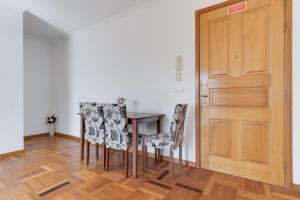- une salle à manger avec une table, des chaises et une porte dans l'établissement Camara de Lobos Apt by HR Madeira, à Câmara de Lobos