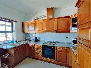 a kitchen with wooden cabinets and a stove top oven at Apartamento do Castelo in Melgaço