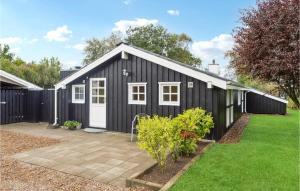a black shed with a white door in a yard at Beautiful Home In Frederikshavn With Kitchen in Frederikshavn