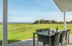 a table and chairs on a patio with a view of the ocean at Three-Bedroom Holiday Home In Nordborg in Nordborg