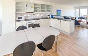 cocina blanca con mesa y sillas en Awesome Home In Assens With 3 Bedrooms And Wifi, en Assens