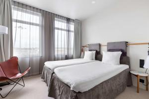 a hotel room with a large bed and a chair at Best Western Plus Sthlm Bromma in Stockholm