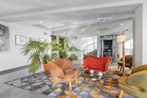 a lobby with chairs and a table and plants at Best Western Plus Sthlm Bromma in Stockholm