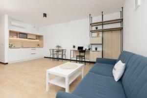 ein Wohnzimmer mit einem blauen Sofa und einem Tisch in der Unterkunft Comfy Studio Targowa next to PGE Narodowy by Renters in Warschau