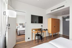 a bedroom with a bed and a desk and a tv at Best Western Plus Sthlm Bromma in Stockholm