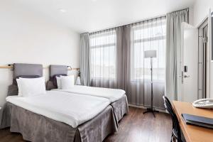 a hotel room with a large bed and a desk at Best Western Plus Sthlm Bromma in Stockholm