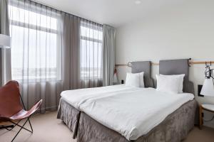 a bedroom with a large bed and a chair at Best Western Plus Sthlm Bromma in Stockholm