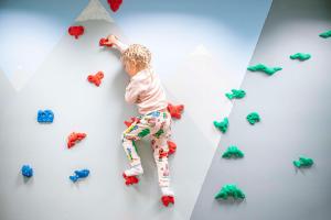 a young child is climbing up a wall with toys at Best Western Plus Sthlm Bromma in Stockholm