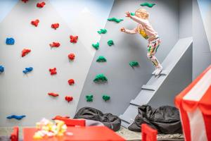a young child climbing a climbing wall in a climbing gym at Best Western Plus Sthlm Bromma in Stockholm