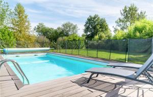 una piscina en una terraza de madera con una silla en La Bourtire, en Le Busseau