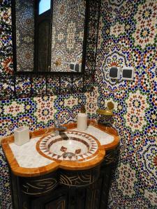 La salle de bains est pourvue d'un lavabo et de carrelage coloré. dans l'établissement Riad Searenity, à Tamraght Ouzdar