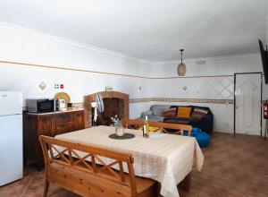 a room with a table and a kitchen with a couch at Luar dos Magos in Salvaterra de Magos