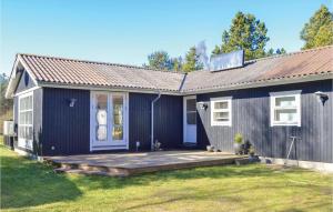 HelberskovにあるBeautiful Home In Hadsund With 3 Bedrooms And Wifiの庭に木製のデッキがある黒い家