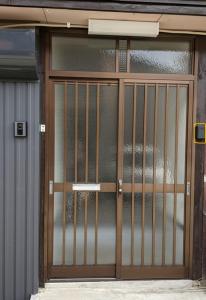 una puerta con una puerta de metal delante de un edificio en Sakura Maru - Vacation STAY 60356v en Takayama