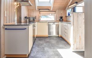 cocina con electrodomésticos blancos y paredes de madera en Beautiful Home In Bogense With Kitchen en Bogense