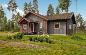 a small house with flowers in front of it at Nice Home In Gunnarskog With Lake View in Gunnarskog