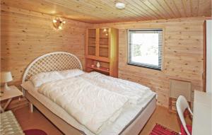 1 dormitorio con 1 cama blanca en una pared de madera en Stunning Home In Frvang With 3 Bedrooms, en Brårup