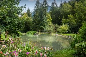 un estanque en un jardín con un banco en La Ferme du Cortet - OVO Network en Thônes