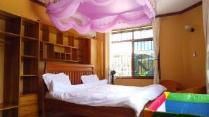 Luxury Villa Garden في دار السلام: غرفة نوم مع سرير بسقف أرجواني