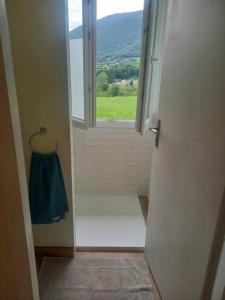 uma casa de banho com um chuveiro, uma janela e uma toalha em Gîte - La Maldina em Oriol-en-Royans