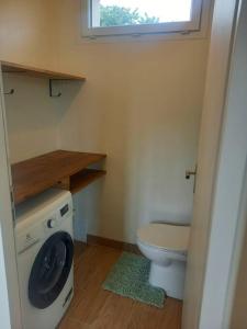 uma pequena casa de banho com WC e máquina de lavar roupa em Gîte - La Maldina em Oriol-en-Royans