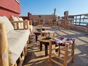 d'une terrasse sur le toit avec des chaises et des tables. dans l'établissement Riad Searenity, à Tamraght Ouzdar
