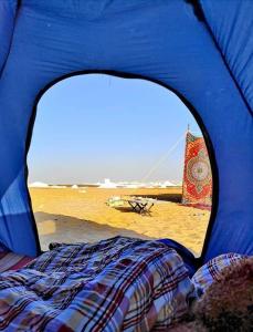 a view of a blue tent with a bed and a beach at White Desert Safari in Bawati