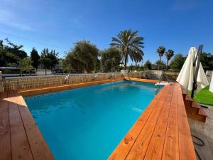 uma grande piscina azul com um deque de madeira em Menahem Arber Pool 5 Bedroom em Tel Aviv