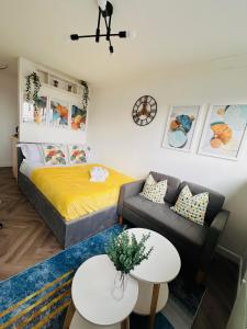 um pequeno quarto com uma cama e um sofá em Private Room in Modern Shared Apartment, Each with Kitchenette, Central Birmingham em Birmingham