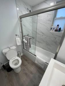 uma casa de banho com um WC branco e um chuveiro em Shirley Air em Boston