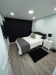 um quarto com uma cama branca e uma mesa de cabeceira em Shirley Air em Boston