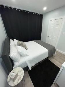 a bedroom with a bed with a black headboard and a table at Shirley Air in Boston