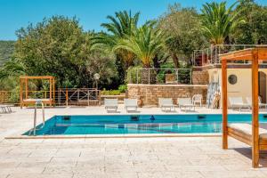 a swimming pool with chairs next to a villa at Gitavillage Talamone in Talamone