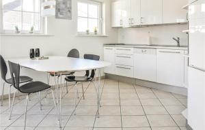 a white kitchen with a table and chairs at Lovely Apartment In Bogense With Sauna in Bogense