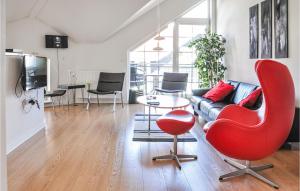 a living room with a red chair and a couch at Lovely Apartment In Bogense With Sauna in Bogense