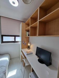 a bedroom with a desk with a computer on it at Coem Livingtel in Goyang